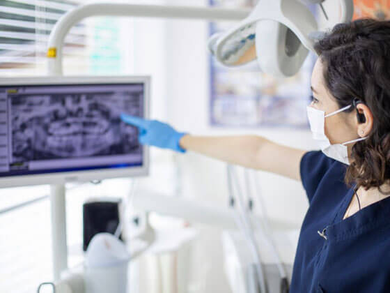 Dentist examining temporomandibular joint disorder on digital scan in Portland dental office.