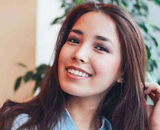 Smiling woman with bright white teeth showcasing the results of professional dental bonding treatment.