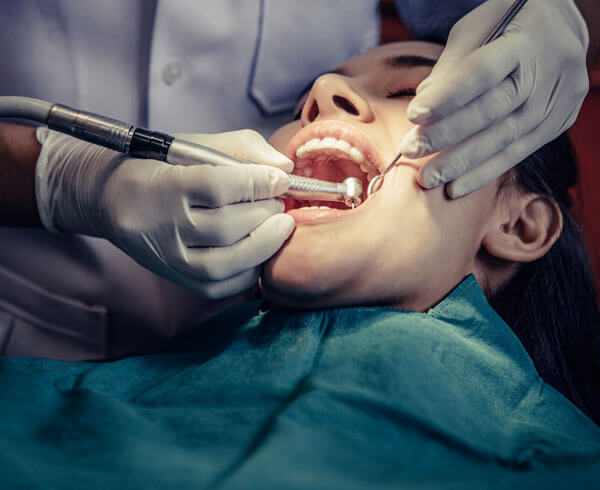 Dentist performing dental bonding procedure on patient's teeth in Portland.