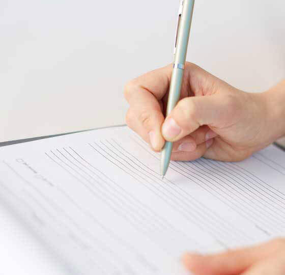 Patient signing new patient form at dental practice in Portland.