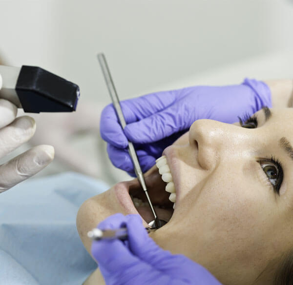 Dentist examining patient's teeth during dental crown consultation and treatment.