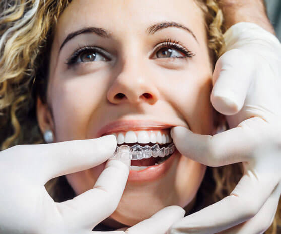 Patient receiving Invisalign clear aligner placement during orthodontic treatment at Portland dental office.