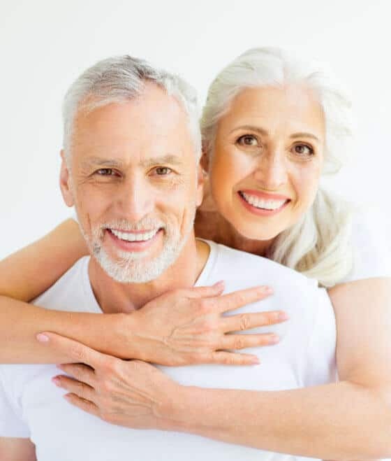 Happy senior couple smiling together, showcasing healthy teeth and dental implant results in Portland.