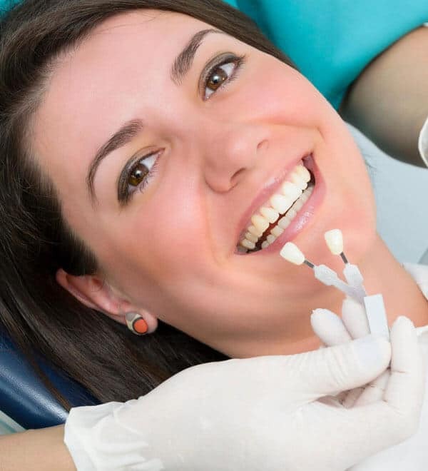 Patient displaying bright white porcelain veneers during dental consultation in Portland.